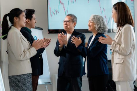 Corporate team celebrating achievement, clapping hands after delivering impactful presentation